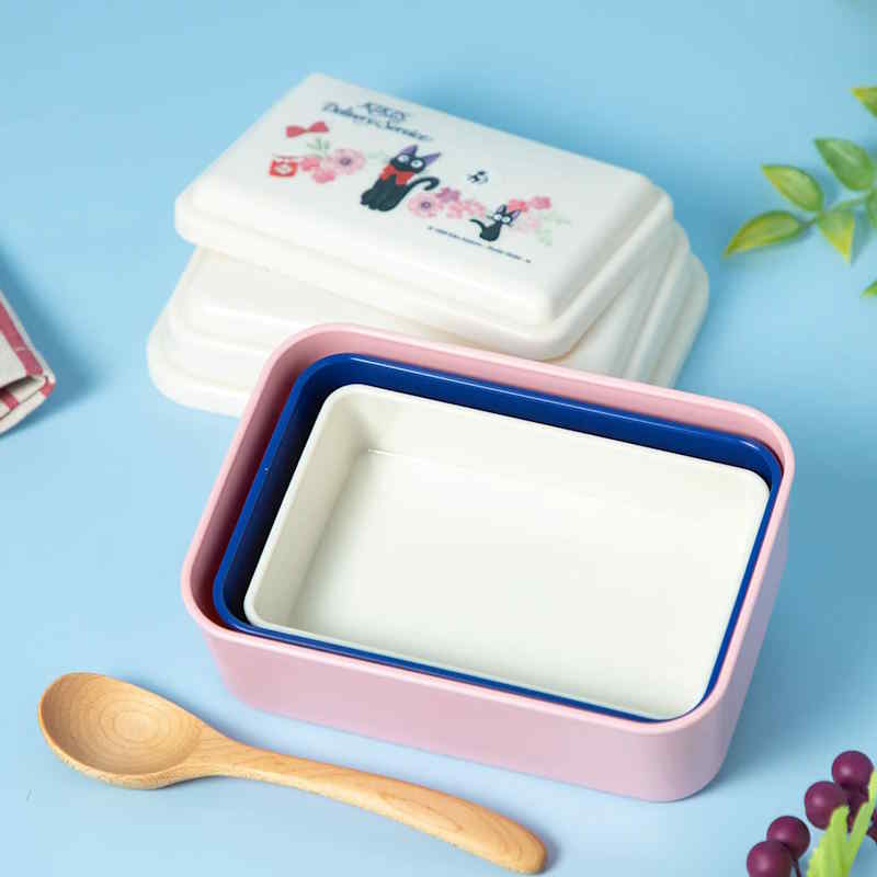 Ensemble de boîtes à lunch japonaises empilables colorées avec une cuillère en bois.